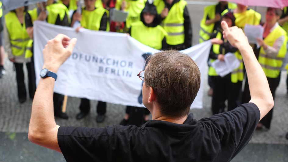 Simon Halsey dirigiert den Rundfunkchor Berlin vor der Komischen Oper